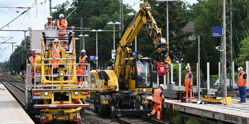 Arbeiter sind im Bahnhof von Walldorf mit schweren Baumaschinen im Einsatz. Diese Woche hat die fünfmonatige Vollsperrung der Bahnstrecke zwischen Frankfurt und Mannheim begonnen. Foto: Arne Dedert (Keystone/DPA)
