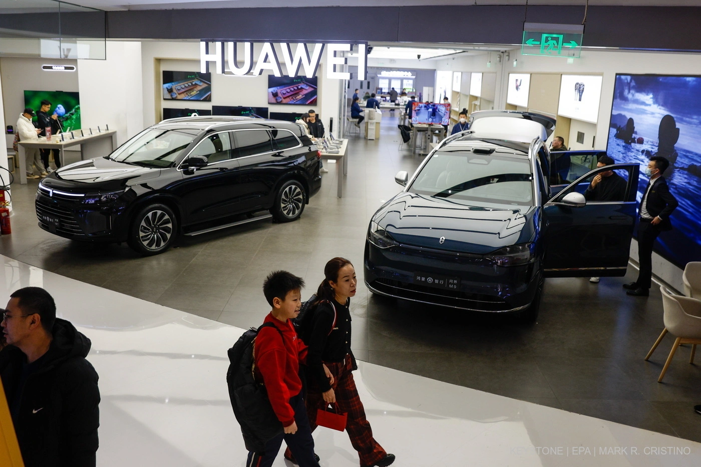 Der Huawei Aito 7 (l) und Huawei Aito M9 (R) können in einem Handyshop im Einkaufszentrum in Peking gekauft werden. Foto: Key/M.R. Christino
