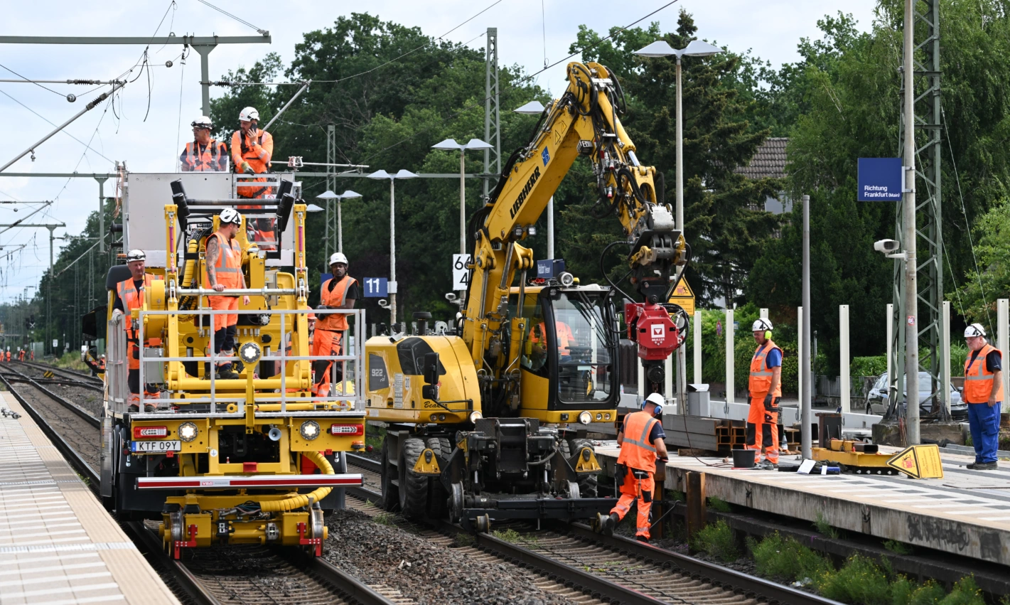 Arbeiter sind im Bahnhof von Walldorf mit schweren Baumaschinen im Einsatz. Diese Woche hat die fünfmonatige Vollsperrung der Bahnstrecke zwischen Frankfurt und Mannheim begonnen. Foto: Arne Dedert (Keystone/DPA)