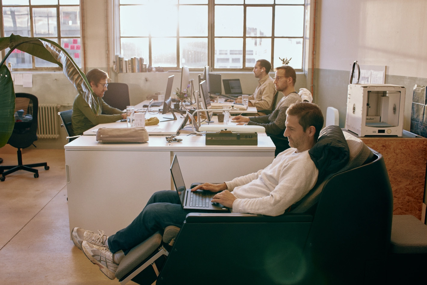 Das Twiliner-Team an seinen Arbeitsplätzen in einer ehemaligen Zahnradfabrik in Zürich Hardbrücke. Im Vordergrund Luca Bortolani, CEO und Mitgründer des Start-ups, im eigens entwickelten Liegesitz. Foto: Silas Zindel